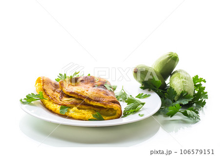 Fried omelette with zucchini,in a plate on a white background. 106579151