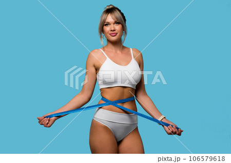 Slim woman in white underwear measure waist with tape Slim woman in white underwear measure waist with tape 106579618