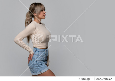 Woman in beige long sleeve and shorts on light background Woman in beige long sleeve and shorts on light background 106579632