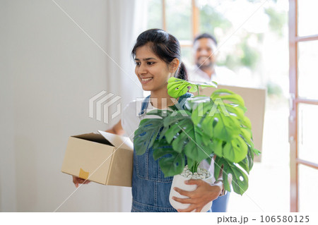 Couple indian happy carrying box on moving day in of home new 106580125