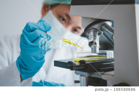 Female researchers are experimenting with pipette dropping a sample into a test tube in an experiment research in laboratory... Female researchers are experimenting with pipette dropping a sample into a test tube in an experiment research in laboratory... 106580686