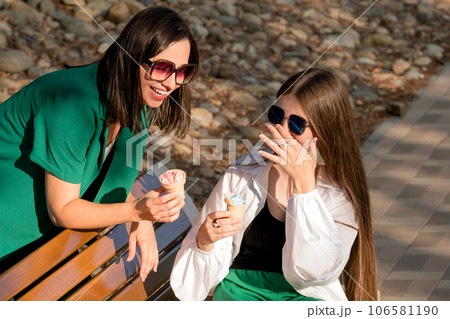 Mom and teenage daughter eat ice cream on walk 106581190
