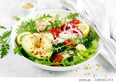 Oatmeal porridge with avocado, cottage cheese, tomatoes, fresh green salad and arugula. Healthy breakfast. Top view 106581253