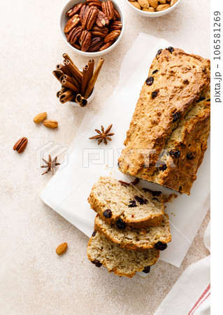 Fruitcake with cranberry, almond and pecan nuts sliced on a wooden board 106581269