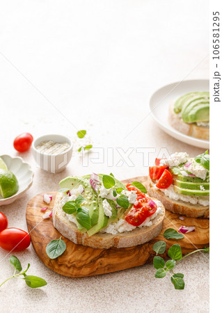 Avocado toast with cheese cottage, tomato and herbs for breakfast 106581295