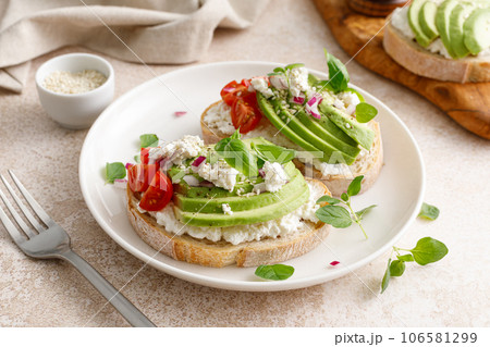 Avocado toast with cheese cottage, tomato and herbs for breakfast Avocado toast with cheese cottage, tomato and herbs for breakfast 106581299