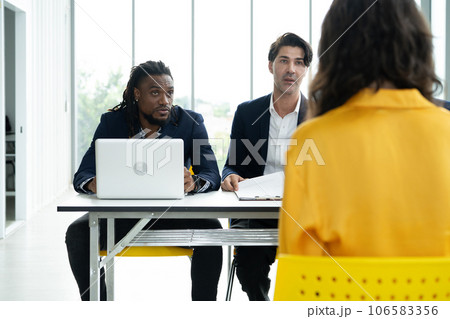 Job interview concept. Diverse hr team doing job interview with a woman in business office. Human resources team interviewing a potential job candidate. Hiring, employment, and recruitment concept. 106583356