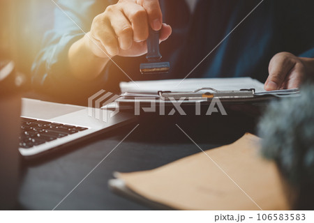 Man stamping approval of work finance banking or investment marketing documents on desk. 106583583