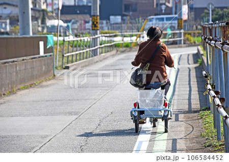 早春の日差しの中三輪自転車に乗るシニア 早春の日差しの中三輪自転車に乗るシニア 106584452
