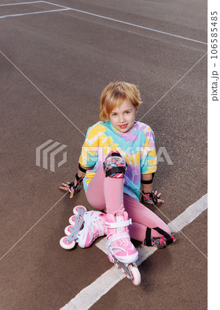 A beautiful little girl learns to roller skate  106585485