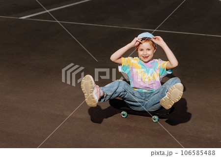 Little girl in jeans on a skateboard 106585488