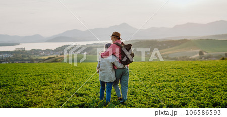 Senior couple standing in the middle of meadow and having romantic moment at the autumn nature. 106586593