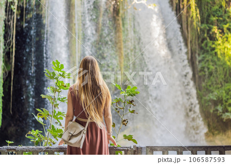 Beautiful woman with long hair on the background of Duden waterfall in Antalya. Famous places of Turkey. Apper Duden Falls 106587593