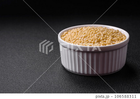 Raw ptitim pasta in a ceramic bowl on a dark concrete background Raw ptitim pasta in a ceramic bowl on a dark concrete background 106588311