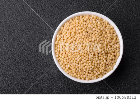 Raw ptitim pasta in a ceramic bowl on a dark concrete background Raw ptitim pasta in a ceramic bowl on a dark concrete background 106588312