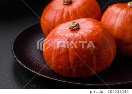 Beautiful fresh round pumpkins in orange color on a dark concrete background 106588336