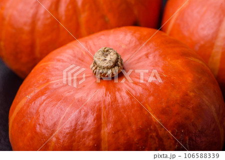 Beautiful fresh round pumpkins in orange color on a dark concrete background 106588339