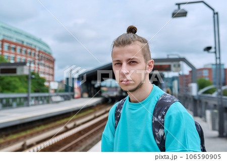 Young male waiting for an electric train at city railway station. Young male waiting for an electric train at city railway station. 106590905