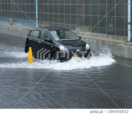豪雨で冠水した道路を走る車 豪雨で冠水した道路を走る車 106593012