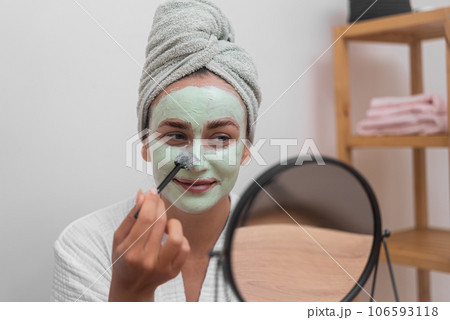 Skin's Rejuvenation: She pampers her face with a moisturizing mask, revealing revitalized, glowing skin at home.  106593118