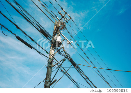 青空の下の電信柱と電線 入り組む各種のケーブル　フィルム調 106596858