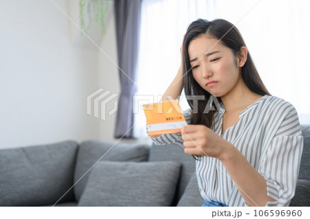 通帳を見る女性 106596960