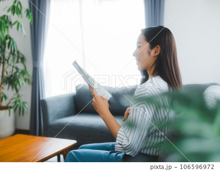 銀行の通帳を見る若い女性 銀行の通帳を見る若い女性 106596972