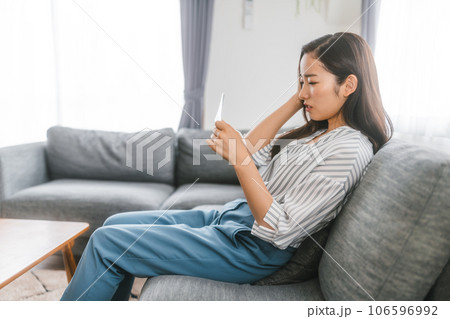 銀行の通帳を見る若い女性 106596992