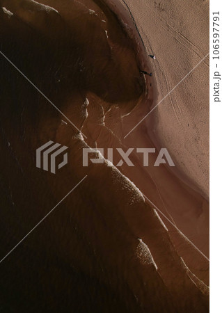 Drone aerial view of waves sea ocean coast. Beach and dunes dark calm sea waves nature landscape captured with drone. Tourism Drone aerial view of waves sea ocean coast. Beach and dunes dark calm sea waves nature landscape captured with drone. Tourism 106597791