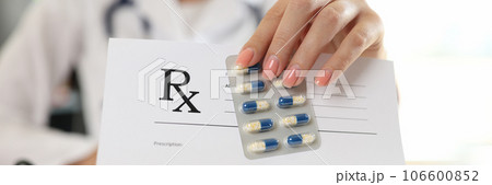 Woman doctor showing blank prescription paper and blister of pills Woman doctor showing blank prescription paper and blister of pills 106600852