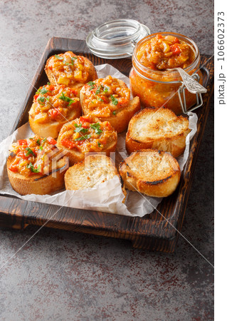 Vegetable spread prepared from eggplant, tomatoes, peppers, onions and garlic close-up on a wooden board. Vertical Vegetable spread prepared from eggplant, tomatoes, peppers, onions and garlic close-up on a wooden board. Vertical 106602373