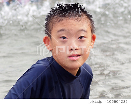 海で遊ぶダウン症候群の男の子 106604283