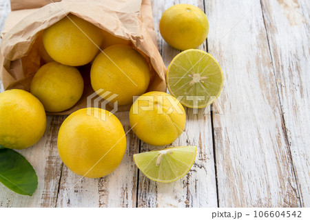 Freshly lemons in paper bag on white wooden table Freshly lemons in paper bag on white wooden table 106604542