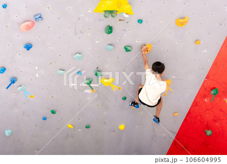 ボルダリングをする小学生の男の子 106604995