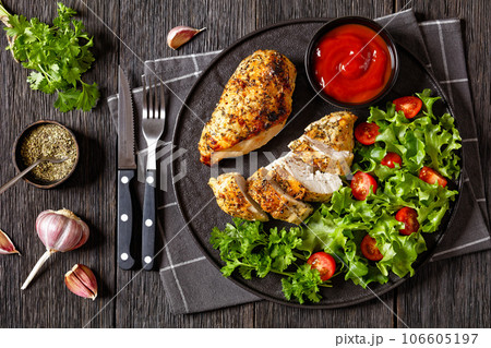 Baked Split Chicken Breasts with salad on plate 106605197