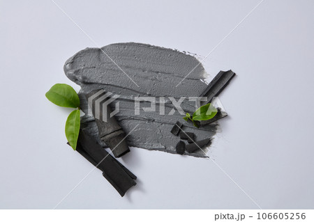 Clay mask texture decorated on gray background with activated bamboo charcoal and green tea leaves. Bamboo charcoal combined with green tea leaves has the ability to clean 106605256