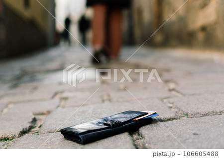 Photo of the sidewalk and legs of a man who lost a black leather wallet while walking Photo of the sidewalk and legs of a man who lost a black leather wallet while walking 106605488