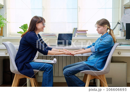 Sad teenage girl at therapy meeting with psychologist 106606693