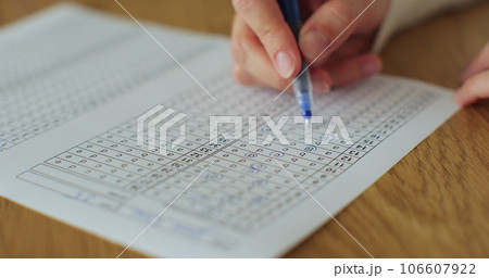 School or university woman students hands taking exams, writing examination room with holding pencil on optical form answers paper sheet. School or university woman students hands taking exams, writing examination room with holding pencil on optical form answers paper sheet. 106607922
