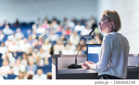 Female speaker giving a talk on corporate business conference. Unrecognizable people in audience at conference hall. Business and Entrepreneurship event Female speaker giving a talk on corporate business conference. Unrecognizable people in audience at conference hall. Business and Entrepreneurship event 106608246