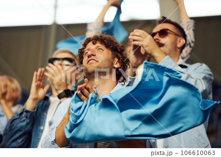 Group young people, friends, sport fans at stadium,cheering emotional up favourite sport team during game Group young people, friends, sport fans at stadium,cheering emotional up favourite sport team during game 106610063