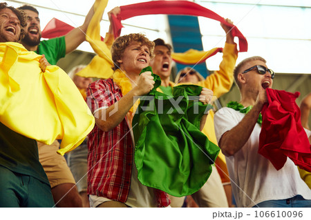 Group of port enthusiast attending football match, emotionally shouting, cheering favorite team during game Group of port enthusiast attending football match, emotionally shouting, cheering favorite team during game 106610096