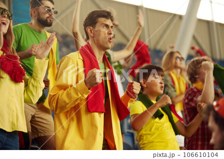 Group of port enthusiast attending football match, emotionally shouting, cheering favorite team during game Group of port enthusiast attending football match, emotionally shouting, cheering favorite team during game 106610104
