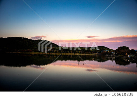 嵯峨野の秋、広沢池の黄昏は影絵のように静かな夕焼けの水鏡、たなびく夕雲 嵯峨野の秋、広沢池の黄昏は影絵のように静かな夕焼けの水鏡、たなびく夕雲 106610839