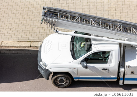 Mover service lifting ladder cargo crane platform vehicle van parked at city street. Retractable furniture elevator machine car pickup truck rental company for relocation and house moving delivery 106611033