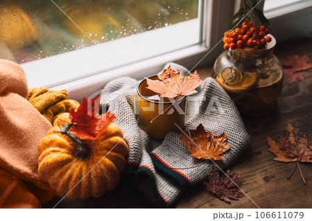 Herbal tea with lemon in glass teapot next to mug on wooden table with maple leaves Herbal tea with lemon in glass teapot next to mug on wooden table with maple leaves 106611079