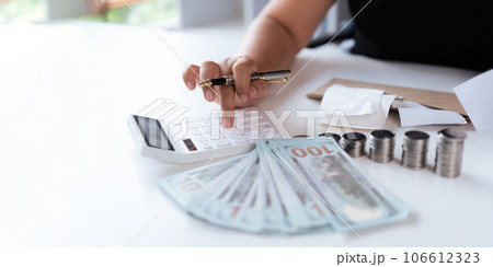 businesswomen is keeping a record of his income and expenses, he plans his finances by using his monthly savings to buy funds to make it grow faster. Concept of saving money for investment businesswomen is keeping a record of his income and expenses, he plans his finances by using his monthly savings to buy funds to make it grow faster. Concept of saving money for investment 106612323