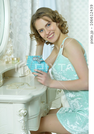 young cute woman with gift at home 106612439