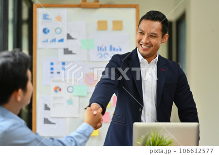 Businesspeople shaking hands after closing deal or successful negotiations at meeting Businesspeople shaking hands after closing deal or successful negotiations at meeting 106612577