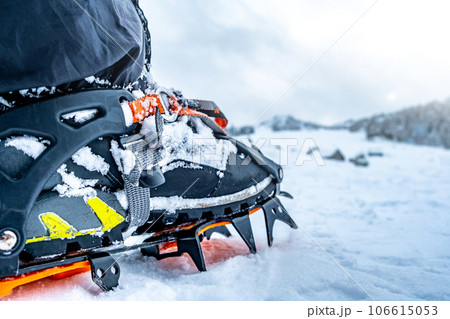 Foot with crampon standing on snow 106615053